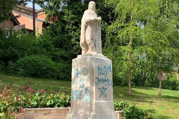 Graffiti of a religious nature on the statue to St Boniface in Newcombes Meadow in 2020. AQ 9613