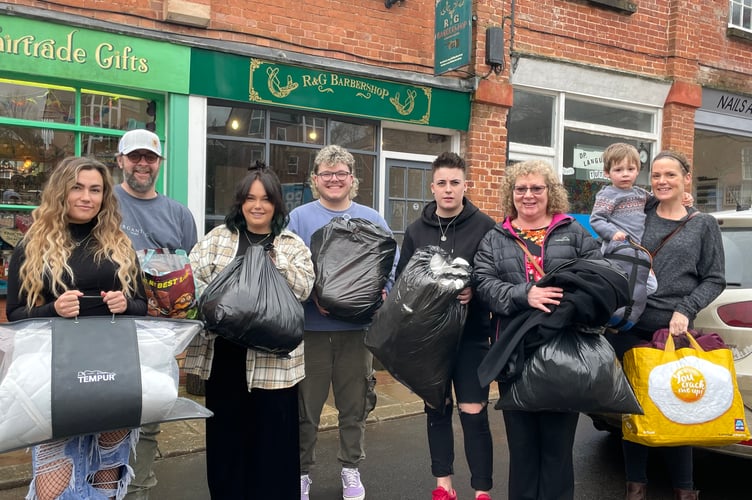 Rob, second left, and staff from R and G Barbers of Crediton, with some of the donations received this week from local people for those forced from Ukraine, with right, Carol Furze and Roselle Brenchley and her son, Seth (3), who took along items to donate. AQ 3958