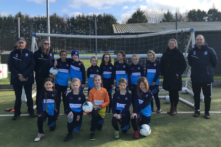 Crediton Youth U9 Girls with coaches Nikki Sandland, Jo Carr from Thomas Westcott, Dan Brenchley and Bruce Abbot receiving the new kit.