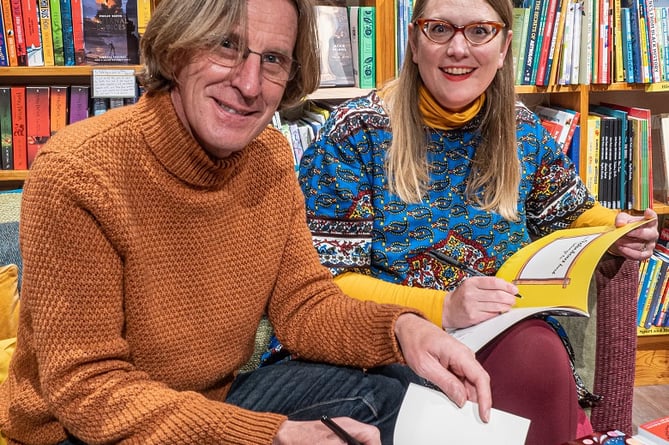 Philip and Sarah signing books.  
