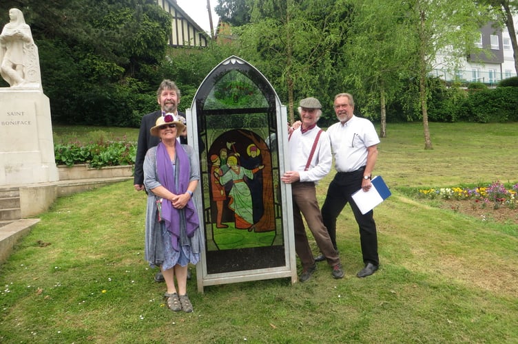 Almost beside the statue of St Boniface and with one of the ‘stained glass panels’ are Stu Wight, Pat Laver and Jenny Start, with story teller Eddie Holden.  SR 1964
