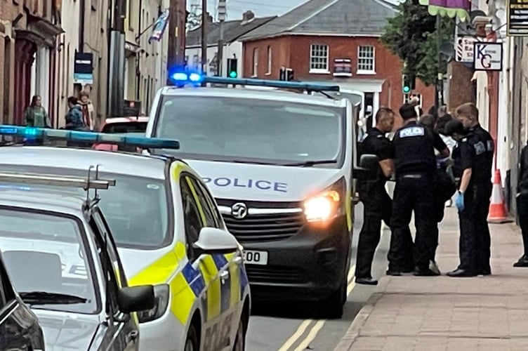 Officers arresting the young man this lunchtime. AQ 9360