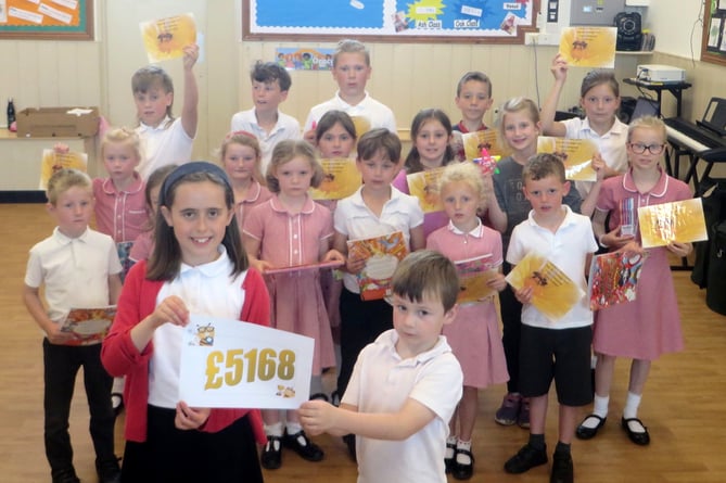 Pupils from Tedburn St Mary Primary School who had raised significant amounts individually with, at front, the oldest and youngest pupils showing off how much they had all raised.  SR 2541
