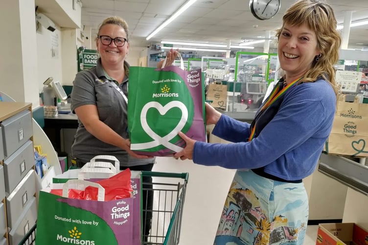 Morrisons Champion Mandy Fosbrooke, left, handing over food items for the Tuck Shop to Youth Worker Catherine Kelly.
