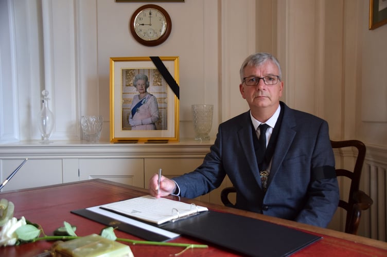 The Chairman of Devon County Council signing the Book of Condolence.