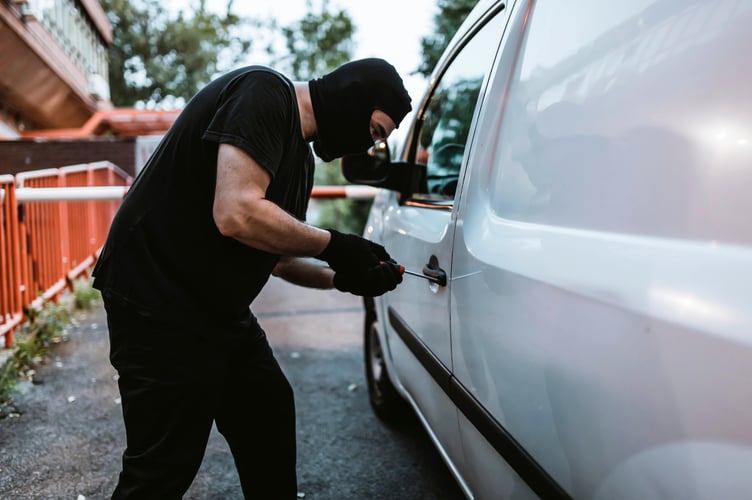 Man with Black Gloves, Balaclava and Screwdriver Trying to Steal a Car.  Robbery Concept. Single Use Approved.