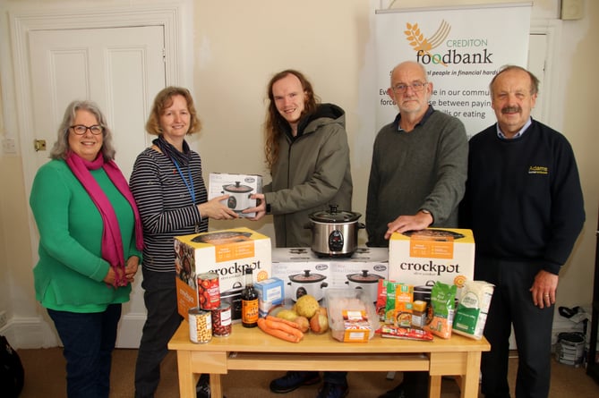 Josh, centre, the first recipient of a Crediton Foodbank slow cooker with, from left, Chris Parsons (chair), Fiona Cochran (Foodbank Co-ordinator), and fourth left, Julian Gebler (volunteer and trustee) and right, David Adams of Adams Home Hardware.  AQ 9288

