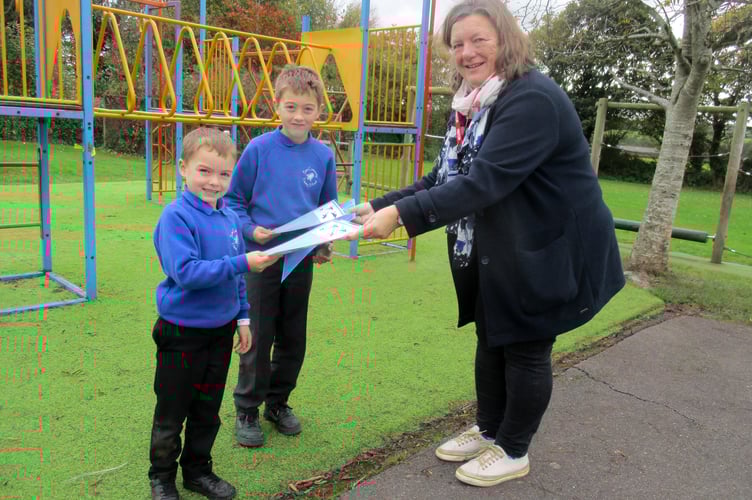 Jo Morgan presenting Archie and Oscar with their certificates after they completed a challenge during the summer holidays.
                               
