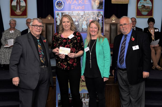 Sharlene and Michelle, centre, from Pippins Pre-School and Nursery, receiving the cheque from Ian Kingsbury, left and Phil Bourne, Crediton Freemason, right.
