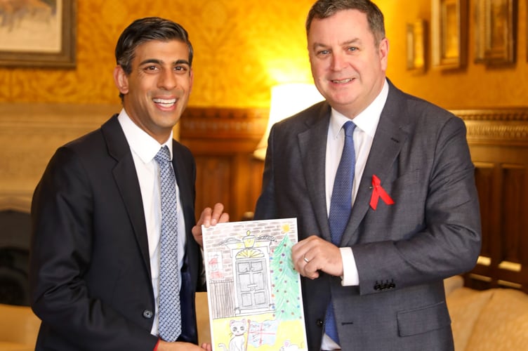 Mel Stride MP giving the PM his Christmas card, designed by Bow Community Primary School pupil Joseph Charlesworth (9). 
