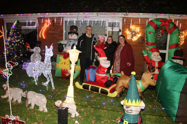 Alan Northcote, his wife Jill and their daughter Lucy with Tilly (2) with a part of the display of lights at 41 Meadowside Road, Sandford. AQ 9414