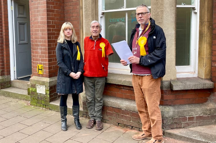 From left, Councillors Sandy Chenore, Frank Letch and John Downes deliver petition forms to Crediton business Ernest Jackson.
