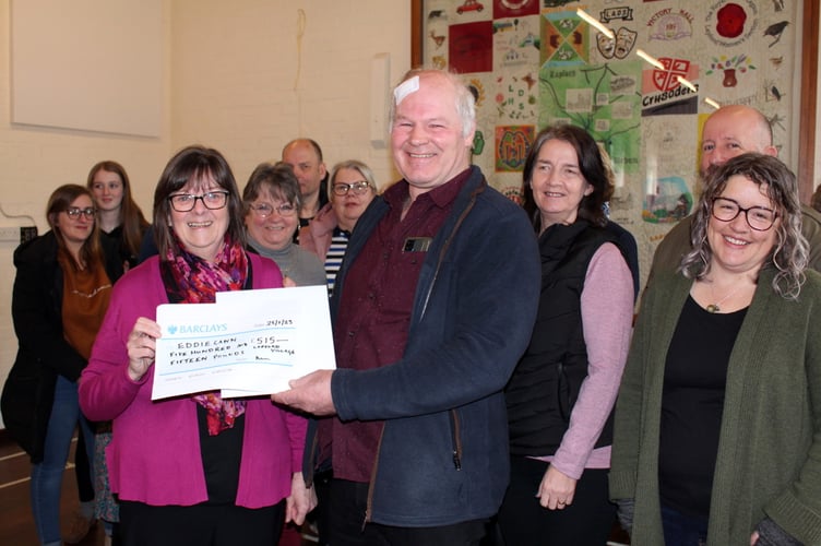 A few of those who gathered at the market with Julie Down, parish council vice chairman, presenting the village gifts to Eddie Cann.  SR  7048
