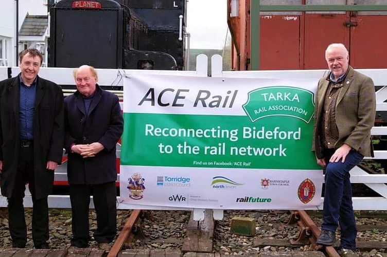 Tim Steer, Dr Michael Ireland and David Northey with the big poster, one of which is at Crediton. 