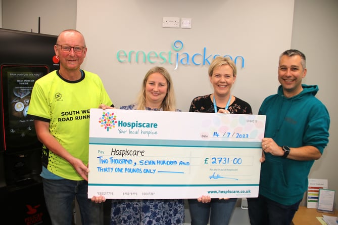 Lee Cusiak from South West Road Runners and Becky Warren from Ernest Jackson and Co, left and Martyn Slyfield, right, from Crediton Running Network, present Ellie Williams, third left, with the cheque for £2,731, for Hospiscare.  AQ 1532