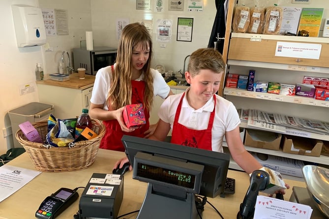 Spreyton Primary School Year 6 students Suzan Dack and Jack Short managing the Thursday morning rush hour with ease, at Spreyton Village Community Shop.