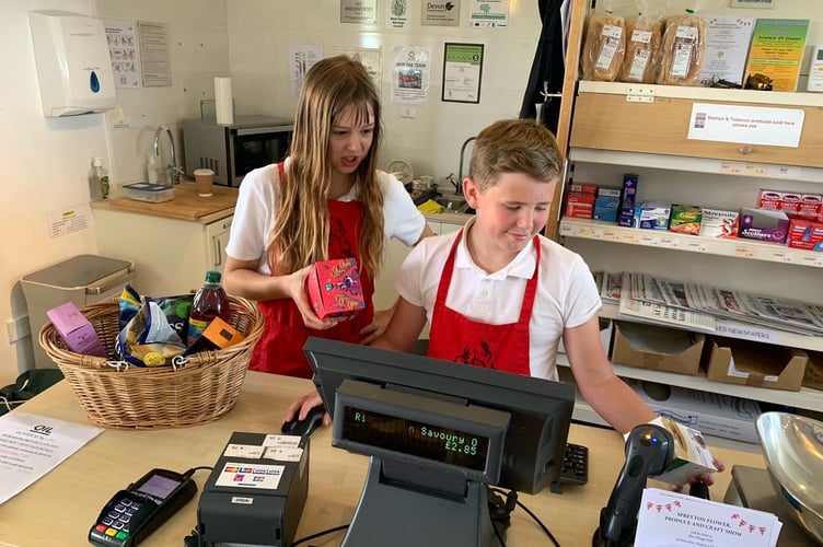 Spreyton Primary School Year 6 students Suzan Dack and Jack Short managing the Thursday morning rush hour with ease, at Spreyton Village Community Shop.