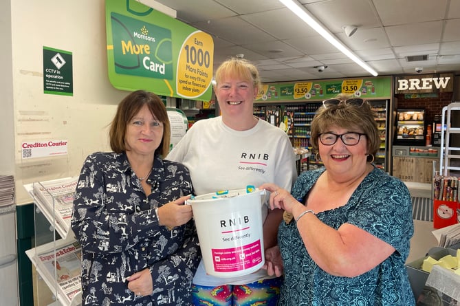 Tricia Sail, centre, when she recently collected donations for the RNIB at Crediton’s Morrisons store.  AQ 1854
