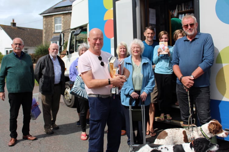 Some of those who chose and returned books from the mobile library in the square at Coldridge, with John Smith, left. SR 8789