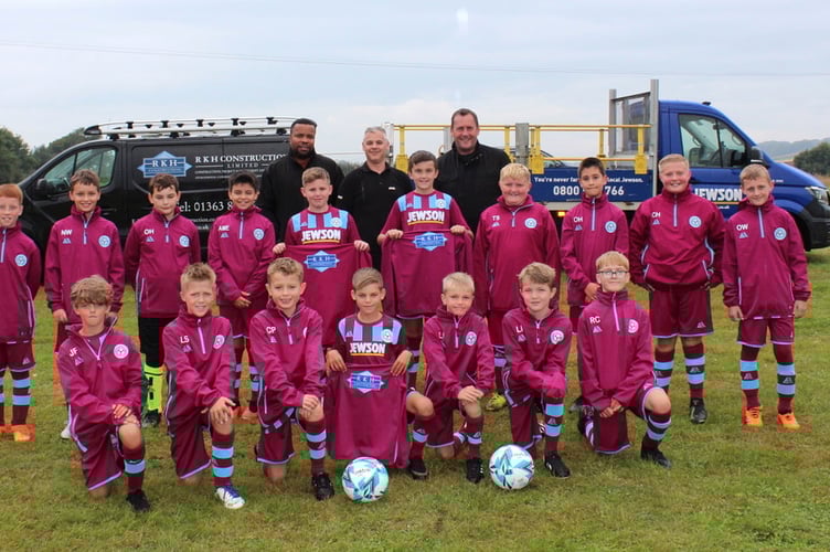 Copplestone Lions in their maroon RKH track suit tops with, left to right, Aaron Foster and Darren Fox of Jewson’s and Rob Holland, owner of RKH Construction Limited. SR 9043