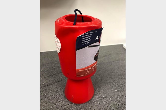 The battered Devon Air Ambulance charity box which was stolen from Crediton Pharmacy and emptied of cash.