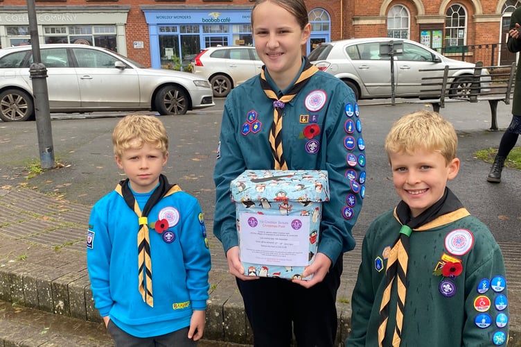 A Beaver, a Cub and Scout from 1st Crediton with one of the Christmas Post boxes that they will be putting out ready for next week.