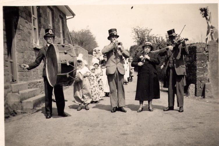 May Day Celebration Band going past Zeal Monachorum Village Hall in the 1930s, from left: Jim Elston (drum), Charlie Greenslade (trumpet), Margaret Quick (penny whistle) and Sidney Snell (violin). Photo by Muriel Greenslade