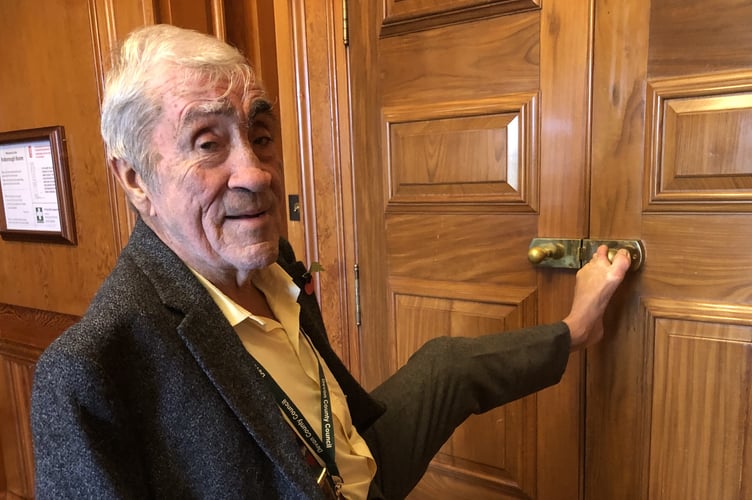 Frank Letch attempting to open one of the County Hall meeting room doors which has round handles.