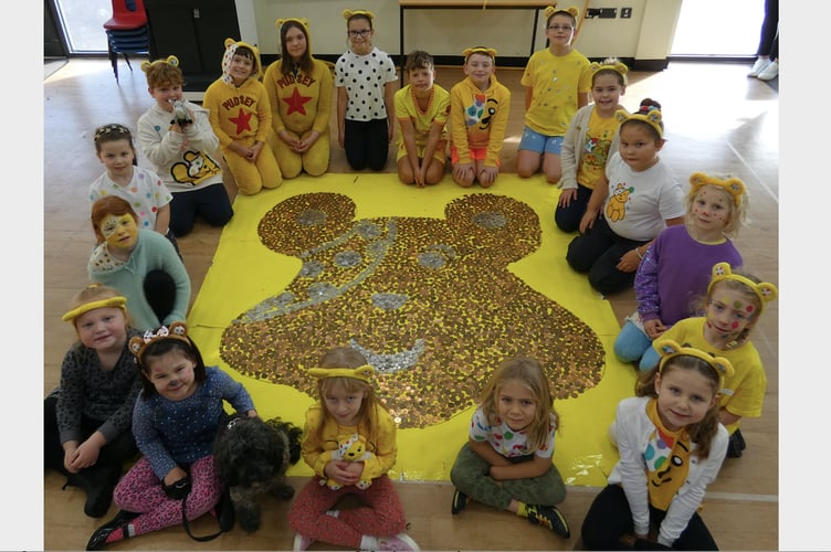 Some of the children from Landscore Primary School with the giant Pudsey head made out of coins for Children in Need.