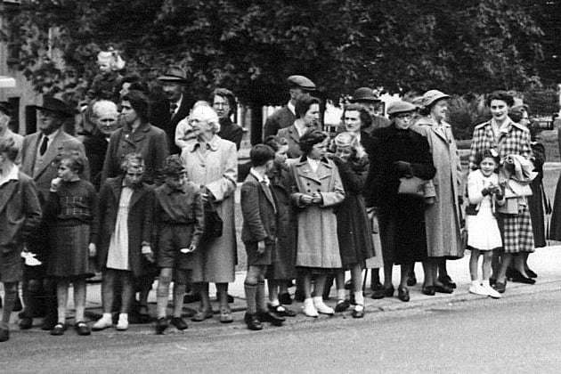 Who do you think they are? Do you recognise anyone in this photo showing part of the crowd lining St Lawrence Green for the Queen’s visit to Crediton in 1956.
