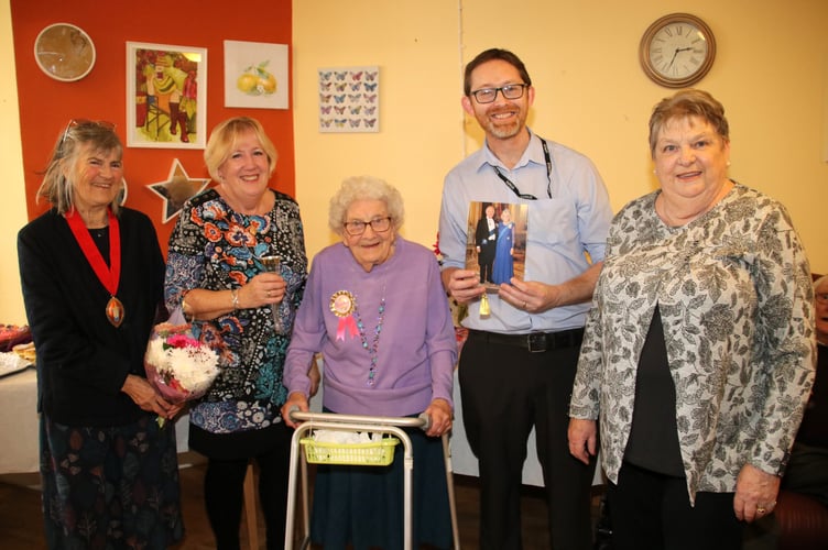 Iris Northcott, centre, with her daughters Jean, second left and Jill, right, with left, the Mayor of Crediton, Cllr Liz Brookes-Hocking and fourth left, Kenwyn Residential Home manager Danny Ruddock holding Iris’s birthday card from the King and Queen.  AQ 2903