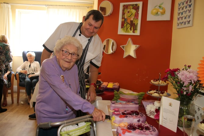 Iris cutting her cake assisted by Kenwyn Residential Home chef. AQ 2907
