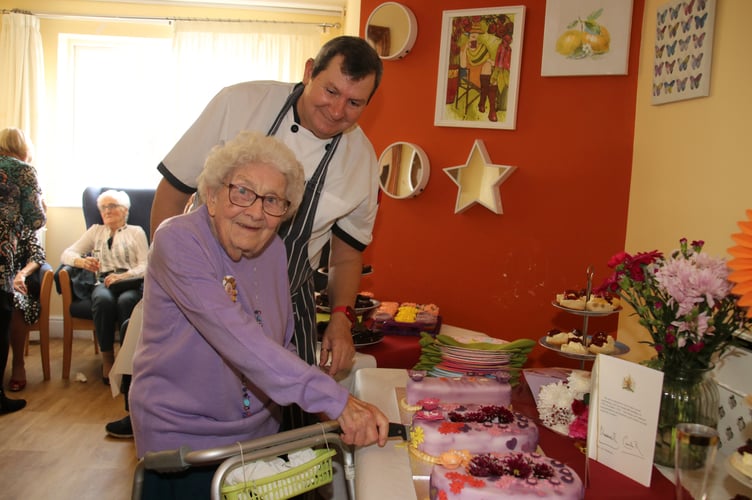 Iris cutting her cake assisted by Kenwyn Residential Home chef. AQ 2907