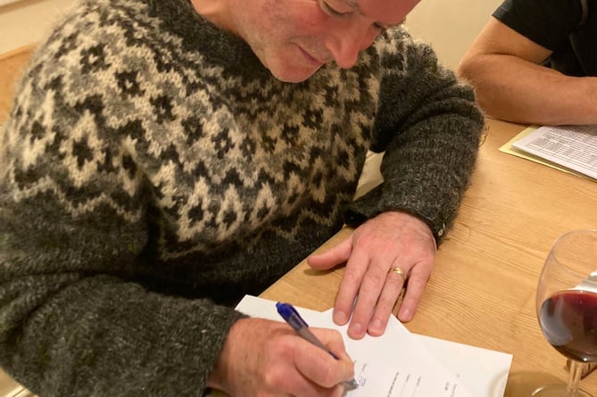 Toby Rubbra, who heads up the Drewe Arms steering group, signing the purchase documents.

