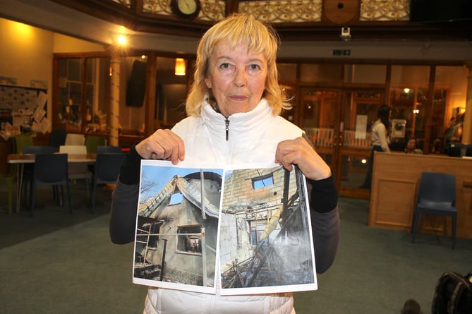Tamara holding pictures of her Ukrainian home near Kiev, which was destroyed by Russian bombing.  AQ 0122
