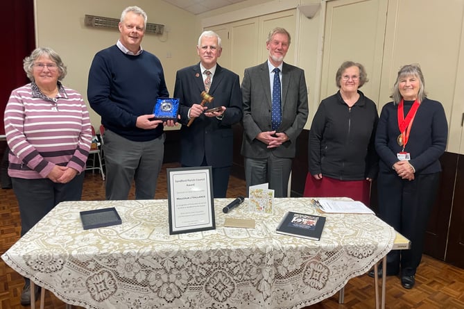 Malcolm Vallance, third left, with the gavel he presented to Sandford Parish Council, with second left, Chairman Richard Ward with the gift of an engraved clock he presented to Malcolm. Left is Jean Howard, with, from fourth left, Paul Snell, Cllr Mrs Margaret Squires and the Mayor of Crediton, Cllr Liz Brookes-Hocking.  AQ 1057
