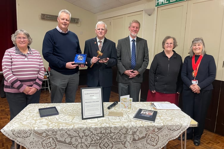 Malcolm Vallance, third left, with the gavel he presented to Sandford Parish Council, with second left, Chairman Richard Ward with the gift of an engraved clock he presented to Malcolm. Left is Jean Howard, with, from fourth left, Paul Snell, Cllr Mrs Margaret Squires and the Mayor of Crediton, Cllr Liz Brookes-Hocking. AQ 1057