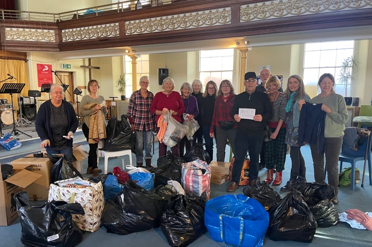 Some of the volunteers who helped sort the clothes donations and pack items into boxes for Refugee Aid.  AQ 1240