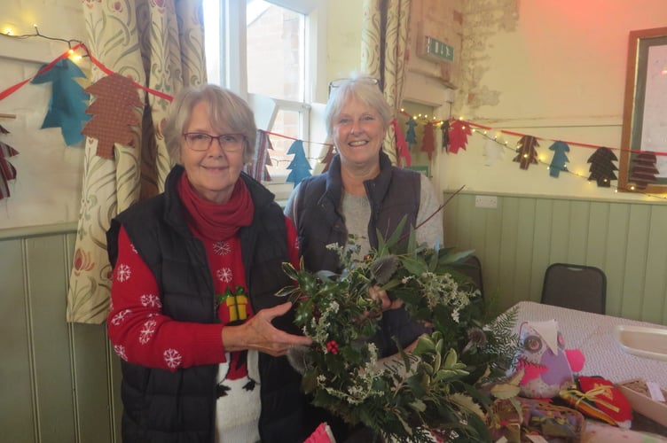 Holding one of the several hand made wreaths for sale.  SR 3387