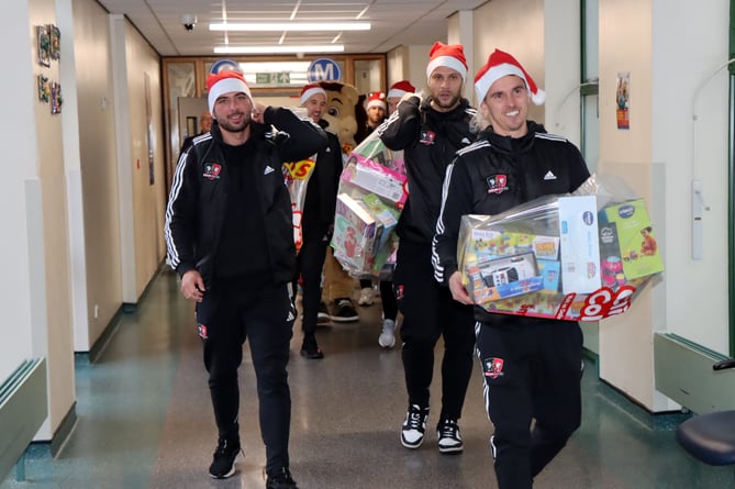 Exeter City FC players delivering presents to children in the Bramble Ward at the Royal Devon and Exeter Hospital.
