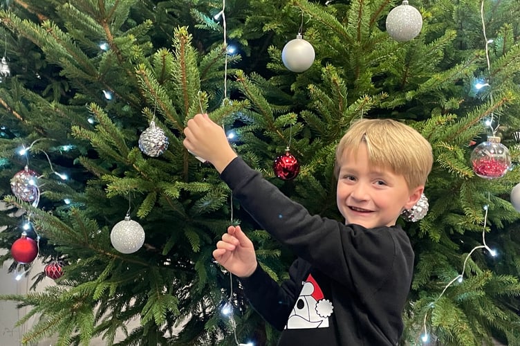Decorating the Christmas tree in the foyer at Redlands Surgery. AQ 1586