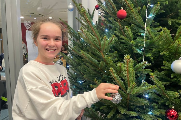 Decorating the Christmas tree in the foyer at Redlands Surgery. AQ 1578