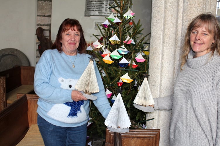 Angela Hawkins (left) and Amanda Down who made 18 of these Christmas trees by folding the pages of books, standing beside the ‘I Saw Three Ships’ tree. SR 9251