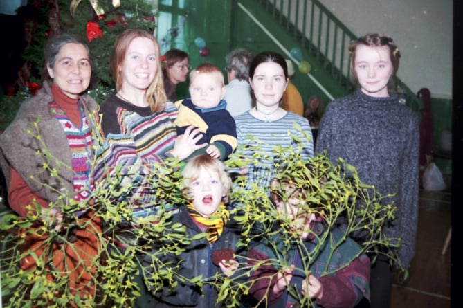 Surrounded by mistletoe are stallholders and helpers at Crediton LETS Christmas Fair in December 1999.  DSC00149
