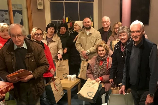 Rotarian President Garry Adams and Rotarian Sheila Ralph to the right of the picture and a group of Ukrainians who have just received their Christmas bags.
