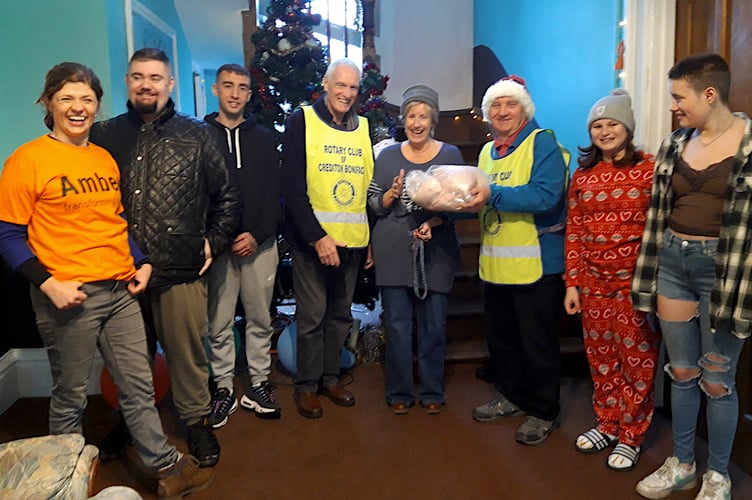 Rotary President Garry Adams and Rotarian Nick Yarnold presenting the turkey to Jennie Rubel (Service Manager) at the Chawleigh Amber Centre. Left is Becky Fry, the fundraising manager of Amber, along with some of the young people who would have enjoyed the turkey on Christmas day.