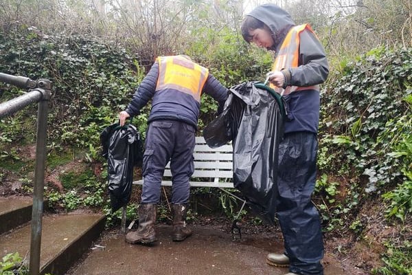 Sweeping leaves on steps in Crediton, one of the team from The Turning Tides Project.