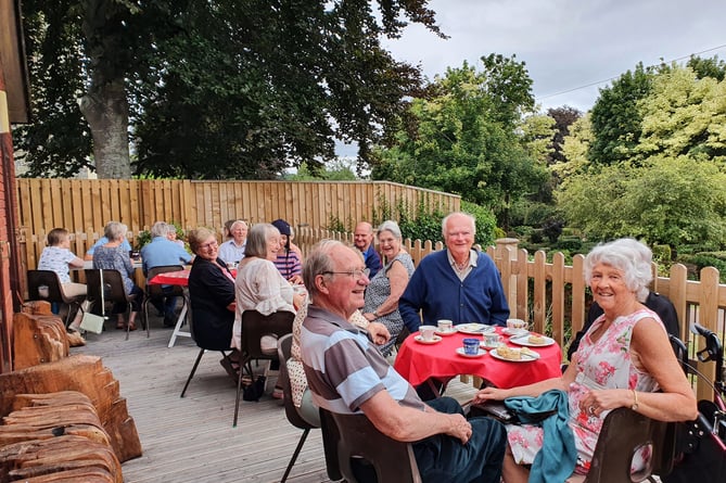 People enjoying a past Friends of Crediton Library event in the community garden.
