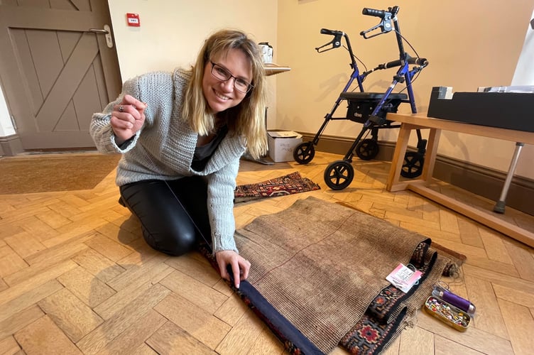 Jo Muncaster repairing a frayed rug at Crediton Repair Cafe last month. AQ 4438