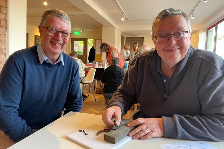 Ian Barnard, right, sharpening items on a grinding stone for one of those who went along. AQ 4448